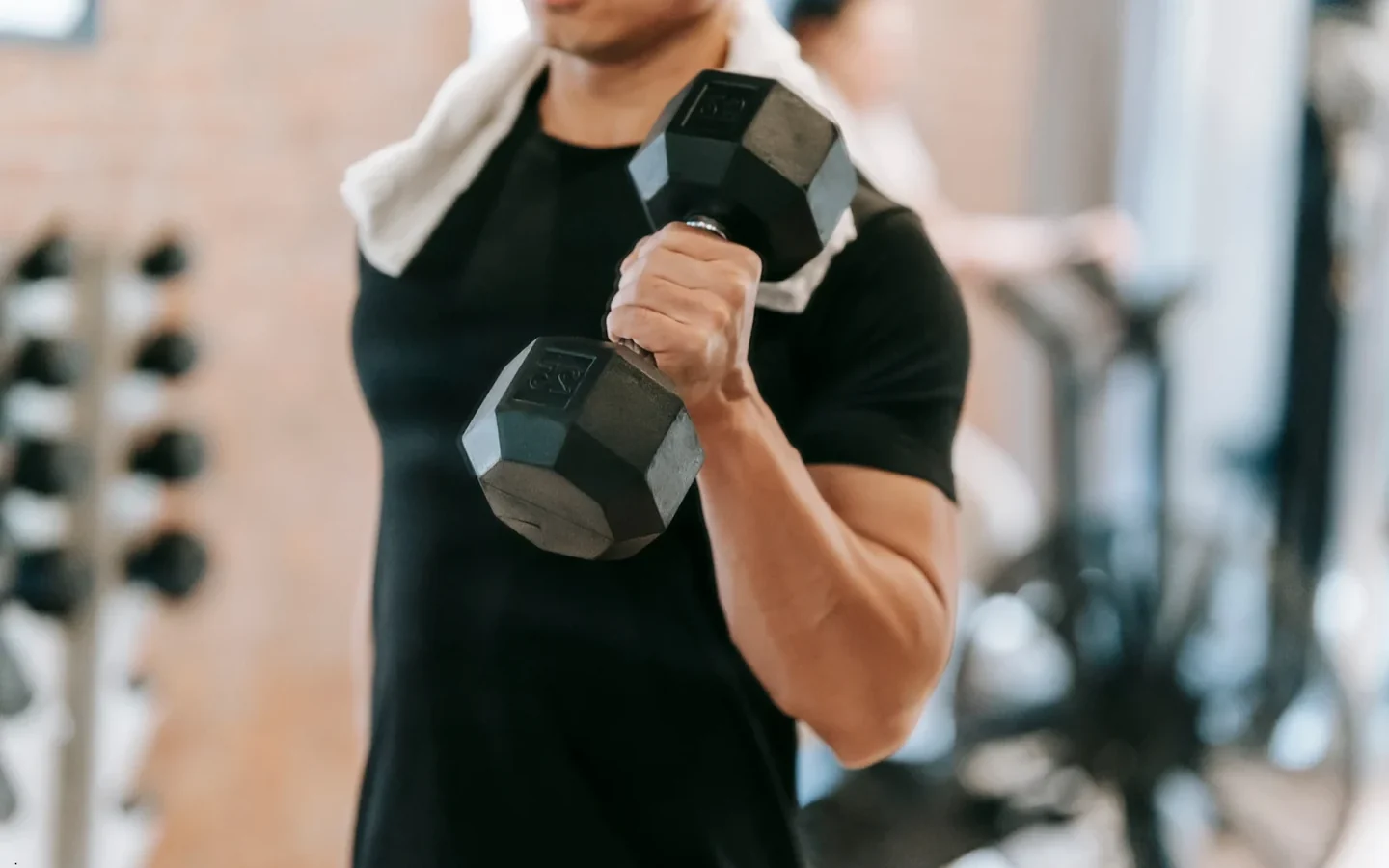 Sportif soulevant un haltère dans une salle de musculation · photo d'illustration
